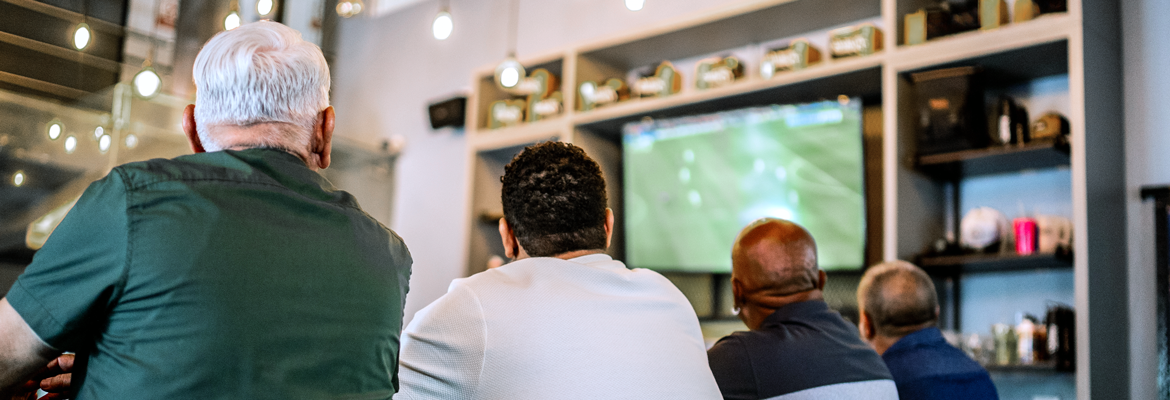 A group of men watching live sports on TV